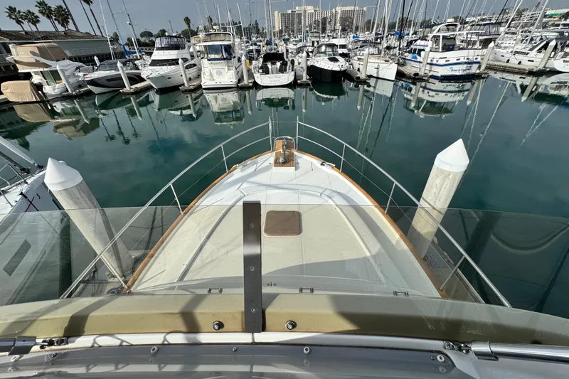 Slide: The Image of 2017 Beneteau Swift Trawler 44 docked in a marina, surrounded by other boats. - 19