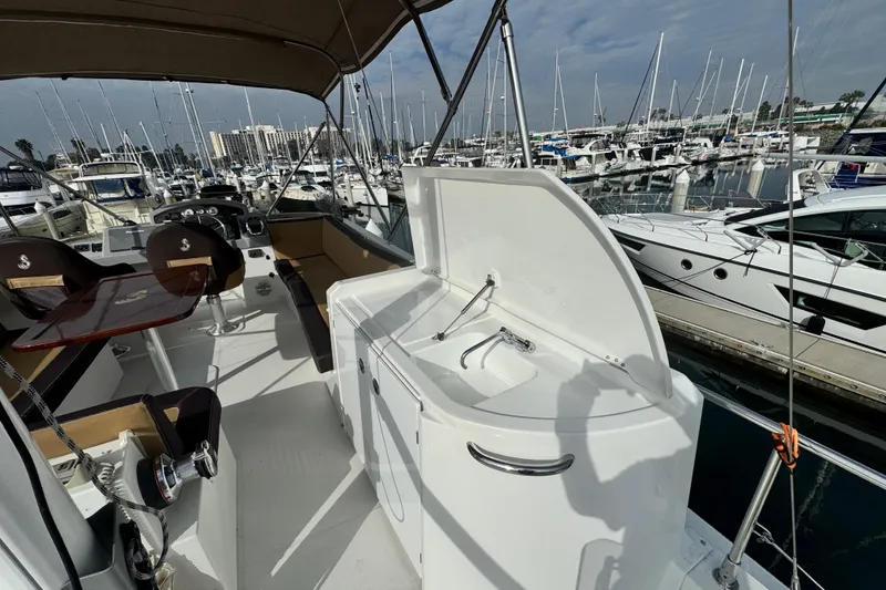 Slide: The Image of 2017 Beneteau Swift Trawler 44 interior with seating and sink, docked at marina. - 22