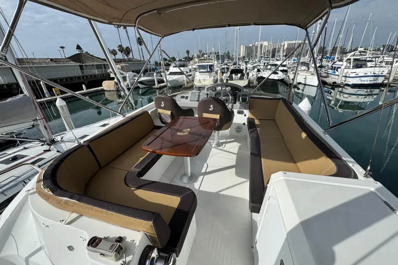 Slide: The Image of 2017 Beneteau Swift Trawler 44 with spacious seating and helm, docked in a marina. - 23
