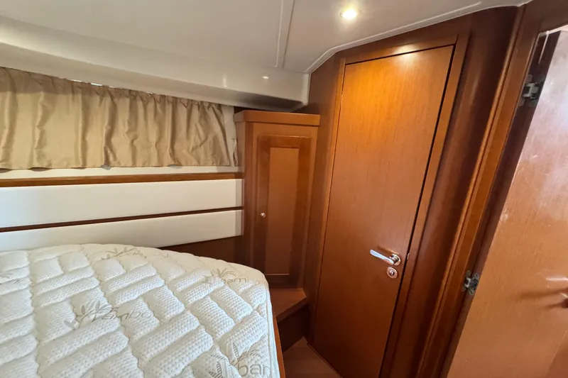 Slide: The Image of 2017 Beneteau Swift Trawler 44 cabin interior with wood finish and cozy bedding. - 28