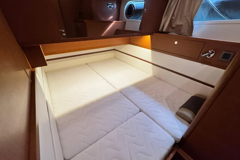 Slide: The Image of 2017 Beneteau Swift Trawler 44 cabin with cozy bed and wooden interior. - 32