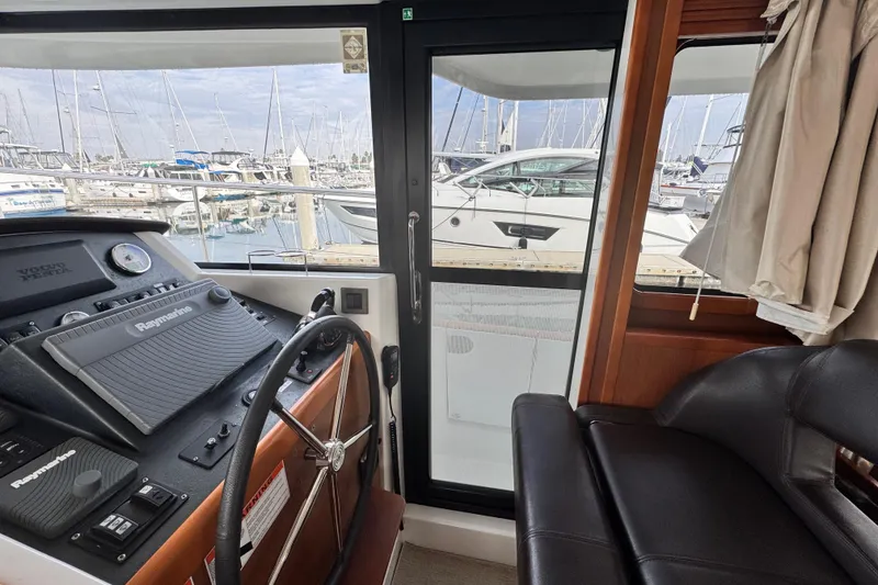 Slide: The Image of Interior helm of 2017 Beneteau Swift Trawler 44, featuring Raymarine equipment and marina view. - 37