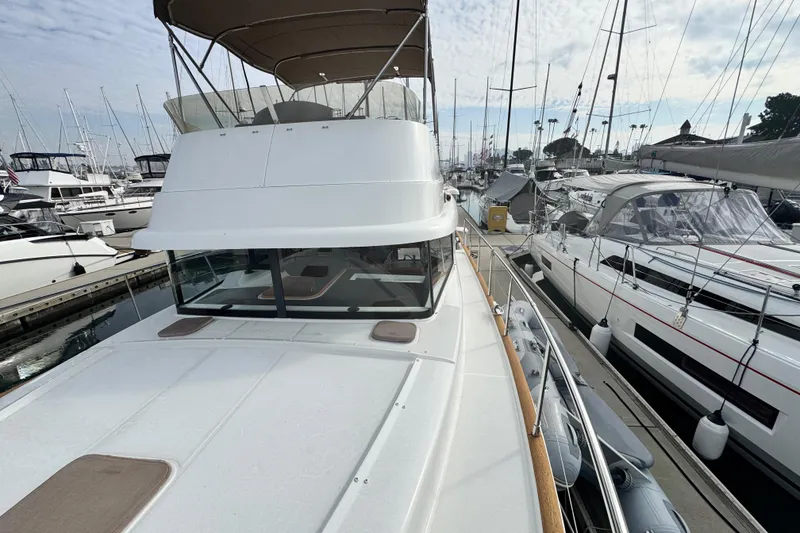 Slide: The Image of 2017 Beneteau Swift Trawler 44 docked at marina, surrounded by sailboats. - 4
