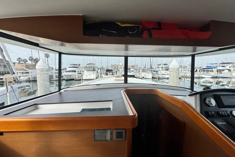 Slide: The Image of Interior view of 2017 Beneteau Swift Trawler 44, showcasing helm and marina through windows. - 40