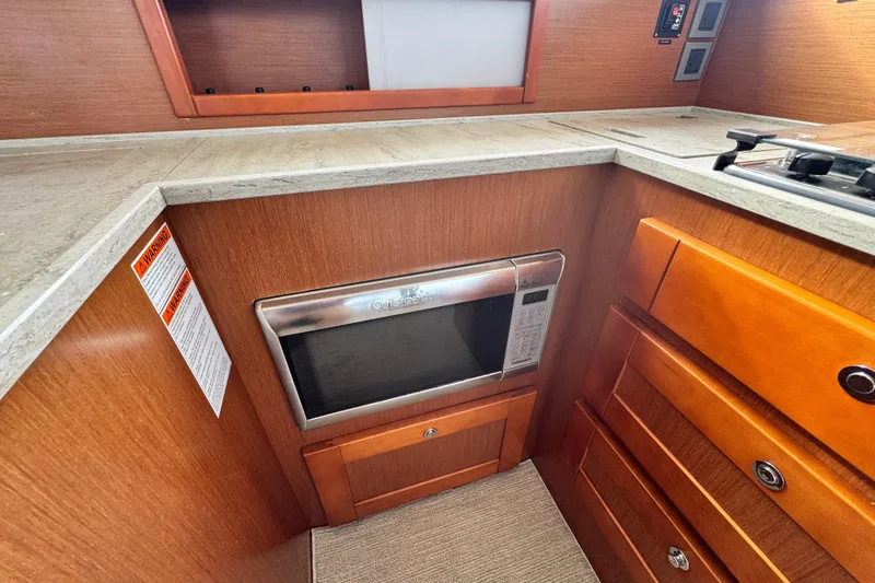 Slide: The Image of 2017 Beneteau Swift Trawler 44 kitchen with microwave and wooden cabinetry. - 41