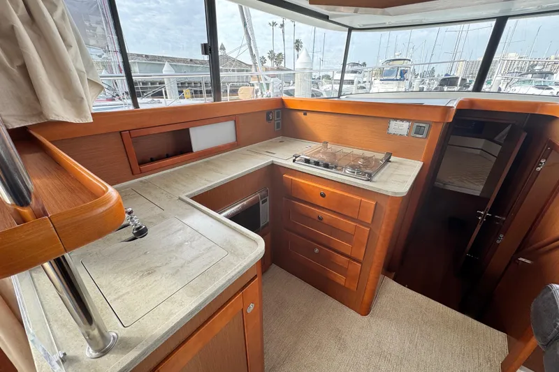 Slide: The Image of 2017 Beneteau Swift Trawler 44 interior kitchen with stove, sink, and wooden cabinetry. - 42