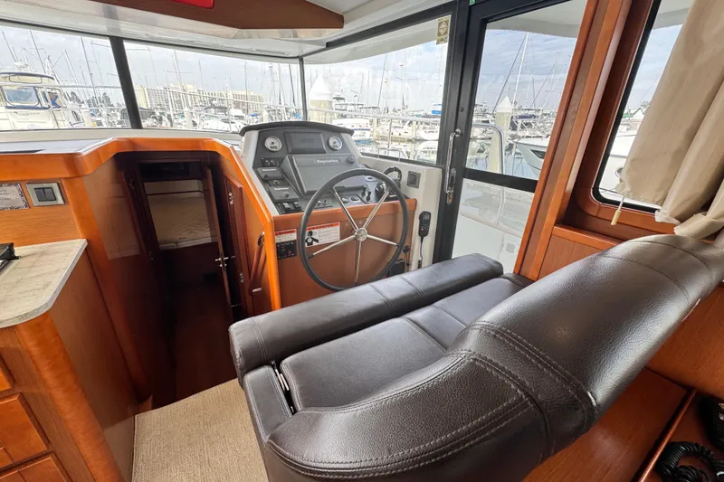 Slide: The Image of 2017 Beneteau Swift Trawler 44 helm station with leather seat and navigation controls. - 44