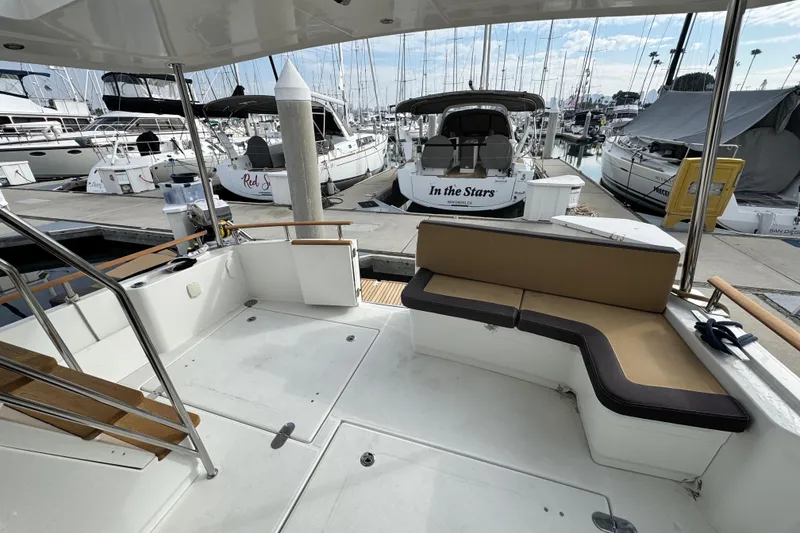 Slide: The Image of 2017 Beneteau Swift Trawler 44 at marina, featuring spacious deck seating. - 51