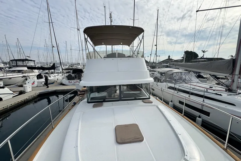 Slide: The Image of 2017 Beneteau Swift Trawler 44 docked in a marina, surrounded by sailboats. - 6