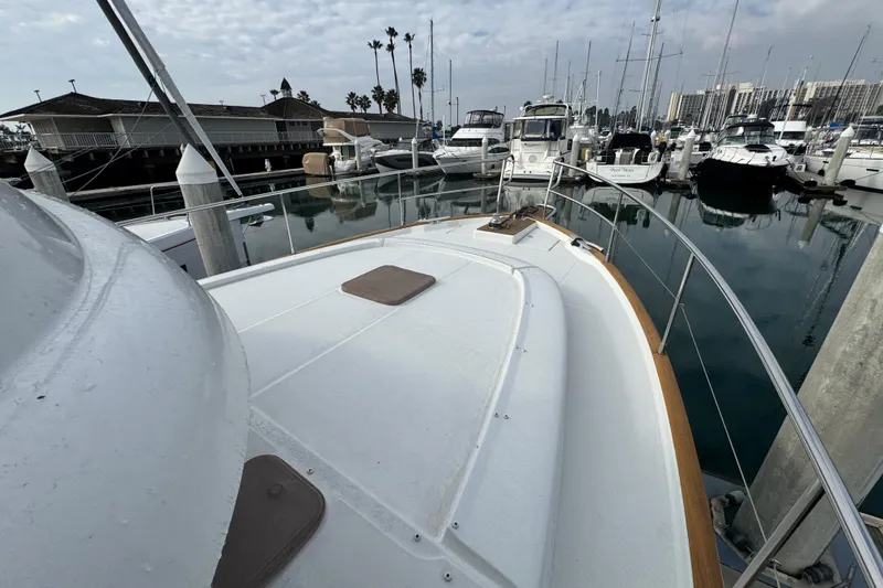 Slide: The Image of 2017 Beneteau Swift Trawler 44 docked in a marina, surrounded by other boats. - 7