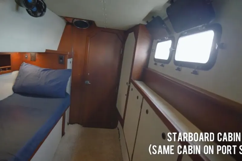 Slide: The Image of Starboard cabin interior of 1985 Custom 60 yacht with bed, storage, and portholes. - 15