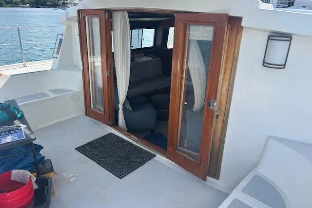 Slide: The Image of Custom 1985 model 60 boat with wooden doors, interior seating, and waterfront view. - 24