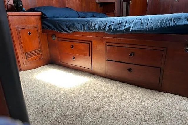 Slide: The Image of Wooden bed with storage drawers, blue bedding, and beige carpet in a 1985 Custom model 60. - 28