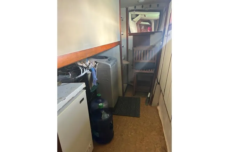 Slide: The Image of Narrow hallway in a 1985 Custom model 60 boat with appliances and storage. - 31