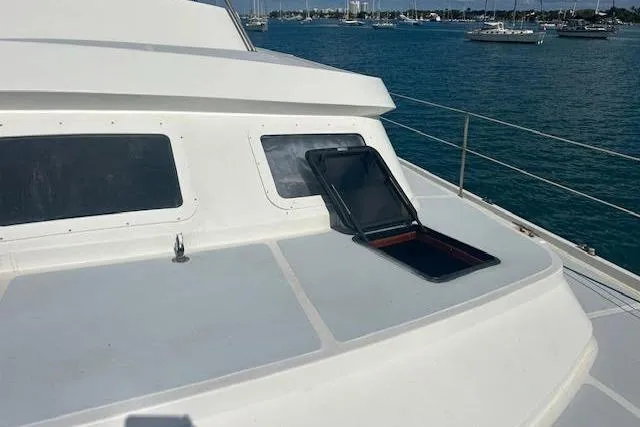 Slide: The Image of Custom 1985 model 60 yacht with open hatch, docked in a serene marina. - 34