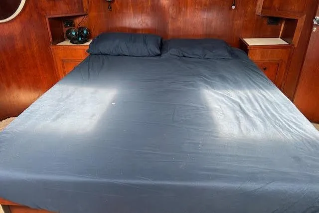 Slide: The Image of Cozy cabin bed with dark bedding in a 1985 Custom model 60 boat interior. - 37