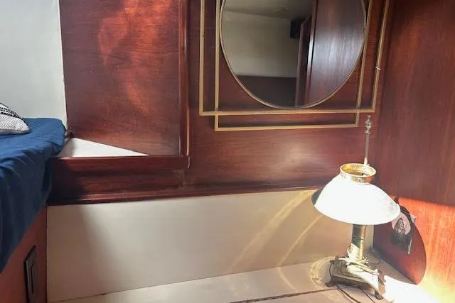 Slide: The Image of Cozy 1985 Custom 60 interior with wooden paneling, round mirror, and vintage lamp. - 40