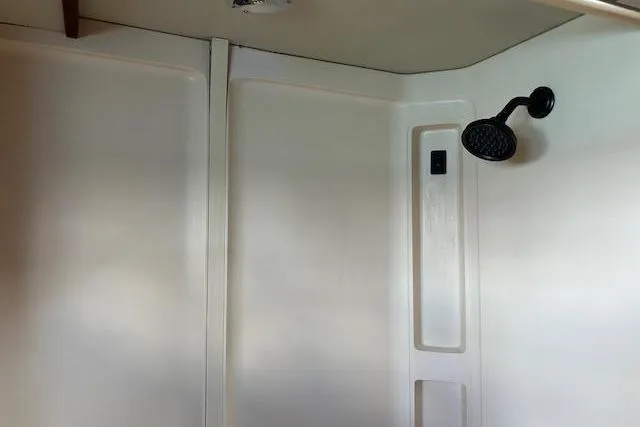 Slide: The Image of Shower interior of a 1985 Custom model 60 with a black showerhead. - 41