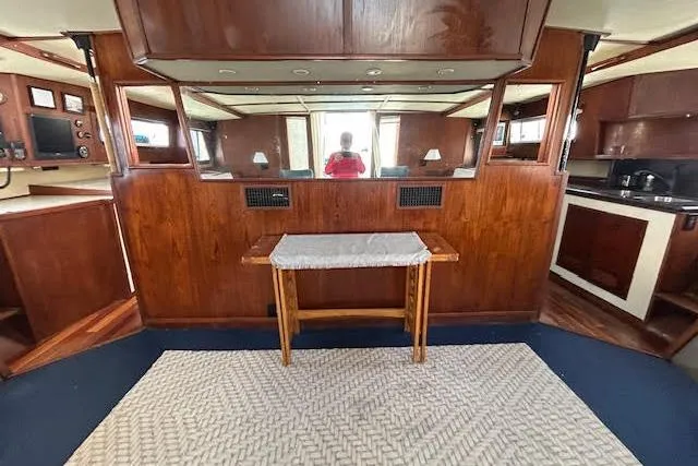 Slide: The Image of Interior of a 1985 Custom Model 60 yacht with wood paneling and a small table. - 46