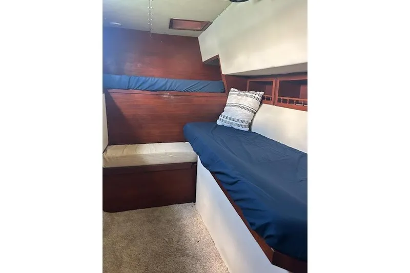 Slide: The Image of Cozy cabin interior of a 1985 Custom model 60 boat with blue bedding. - 52