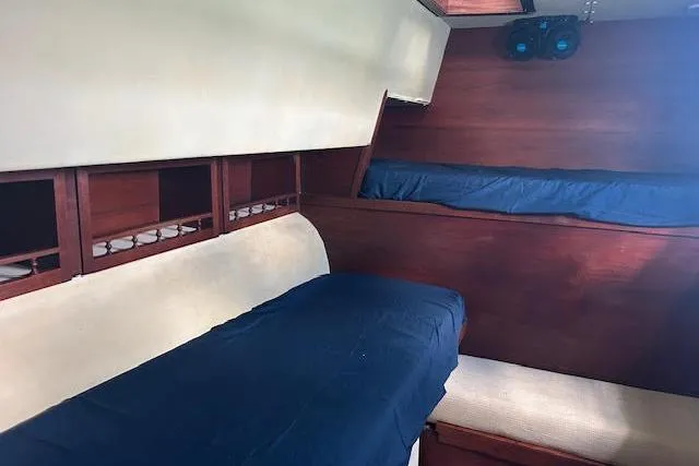 Slide: The Image of Interior of 1985 Custom 60 boat with wooden bunks and blue bedding. - 53