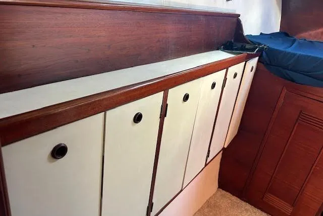 Slide: The Image of Wooden interior cabinets in a 1985 Custom 60 model, featuring white doors and circular handles. - 55