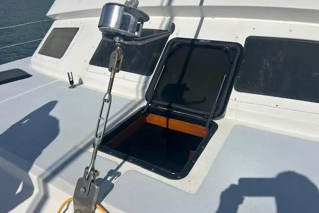 Slide: The Image of Open hatch on 1985 Custom 60 sailboat deck with visible winch and shadows. - 61