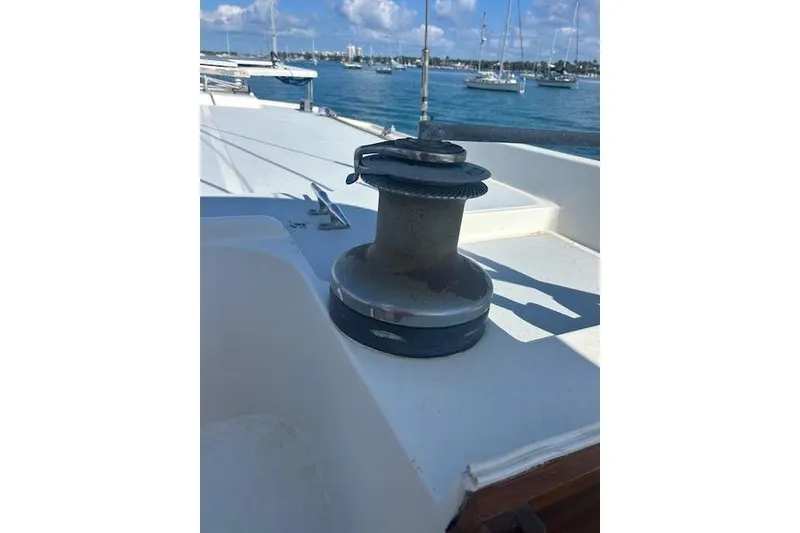Slide: The Image of Winch on 1985 Custom 60 sailboat deck, with marina and boats in background. - 63