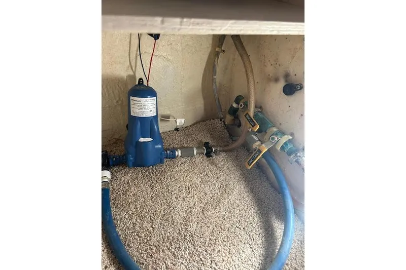 Slide: The Image of Blue water pump system with hoses on carpeted floor, Custom model 60, 1985. - 65