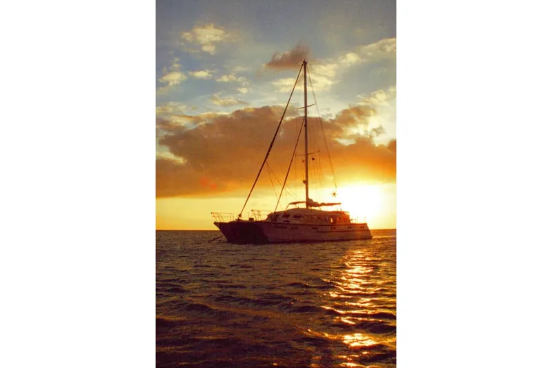 Slide: The Image of Sailboat silhouetted against a vibrant sunset, Custom 60 model, 1985. - 69