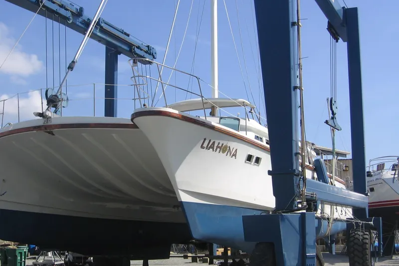 Slide: The Image of Custom 1985 model 60 boat named "Liahona" on a lift at a marina. - 8