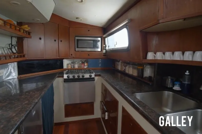 Slide: The Image of Galley kitchen in 1985 Custom model 60 boat with wooden cabinets and modern appliances. - 9