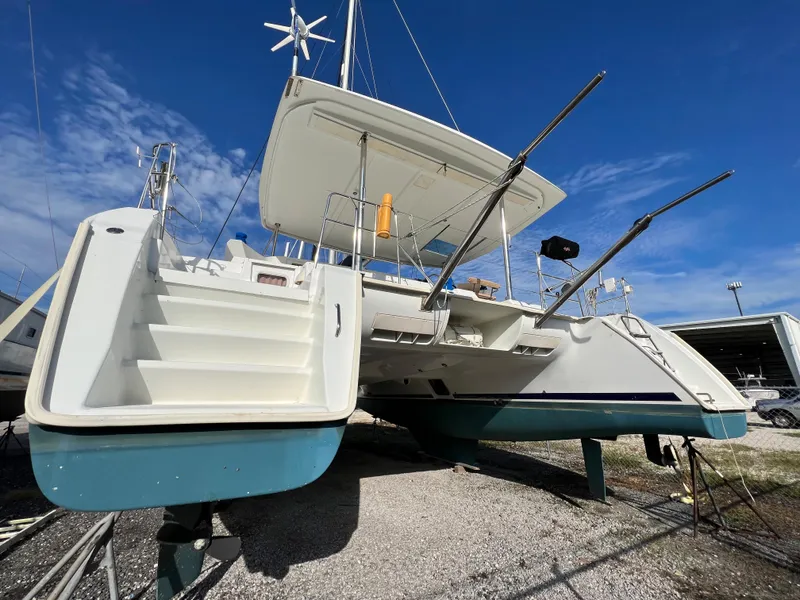 Slide: The Image of 2008 Lagoon 420 catamaran on dry dock under clear blue sky. - 10