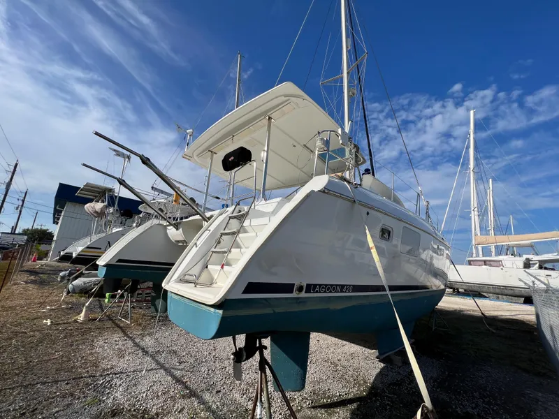 Slide: The Image of 2008 Lagoon 420 catamaran on dry dock under clear blue sky. - 11