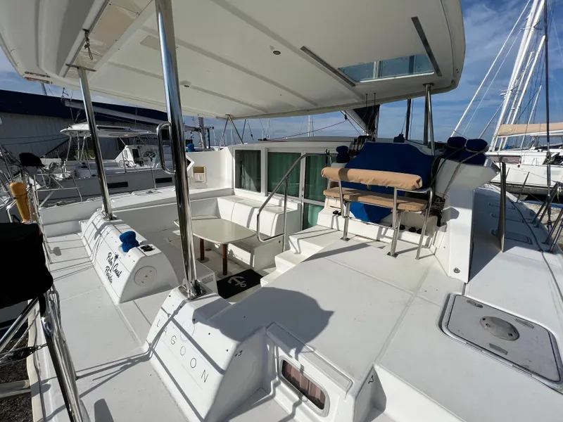 Slide: The Image of Lagoon 420 catamaran 2008 model, spacious deck with seating and table, docked at marina. - 12