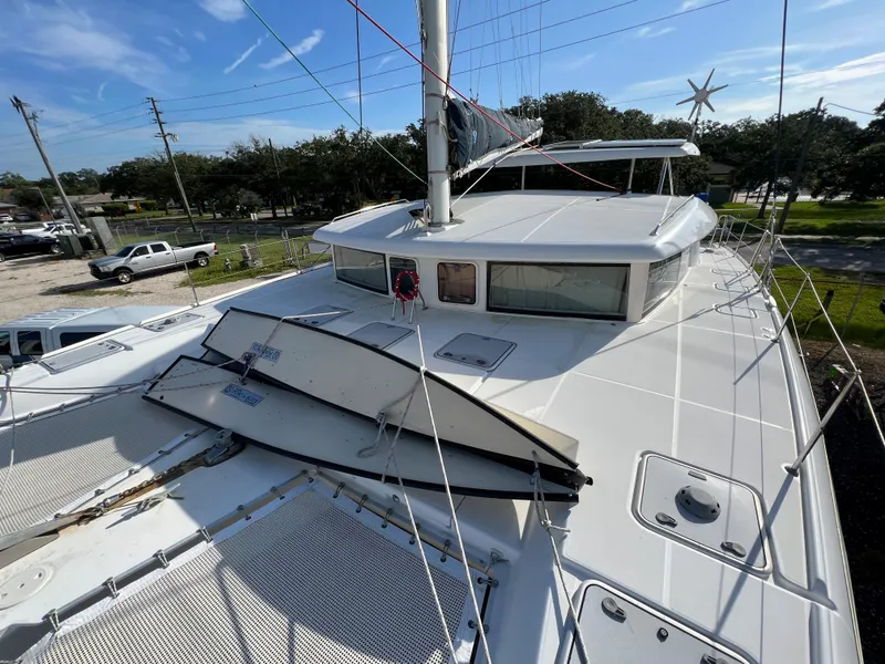 Slide: The Image of Lagoon 420 catamaran 2008 model, deck view with mast and rigging, parked on land. - 13
