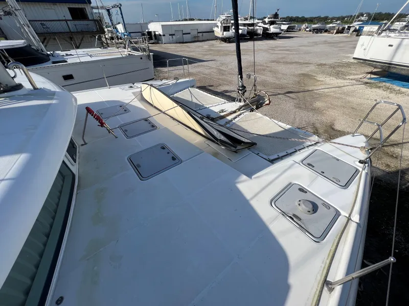 Slide: The Image of 2008 Lagoon 420 catamaran on dry dock, showing deck and hatches. - 15