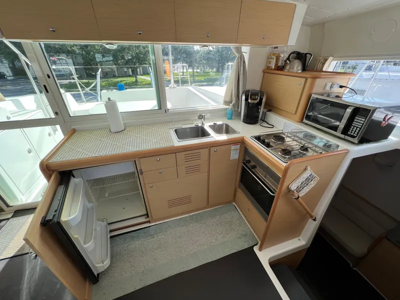 Slide: The Image of 2008 Lagoon 420 catamaran kitchen with stove, sink, fridge, and microwave. - 26