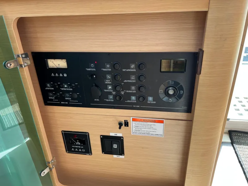 Slide: The Image of Control panel of a 2008 Lagoon 420 catamaran with various switches and gauges. - 27