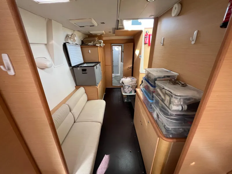 Slide: The Image of Interior of 2008 Lagoon 420 catamaran with beige seating and storage containers. - 31