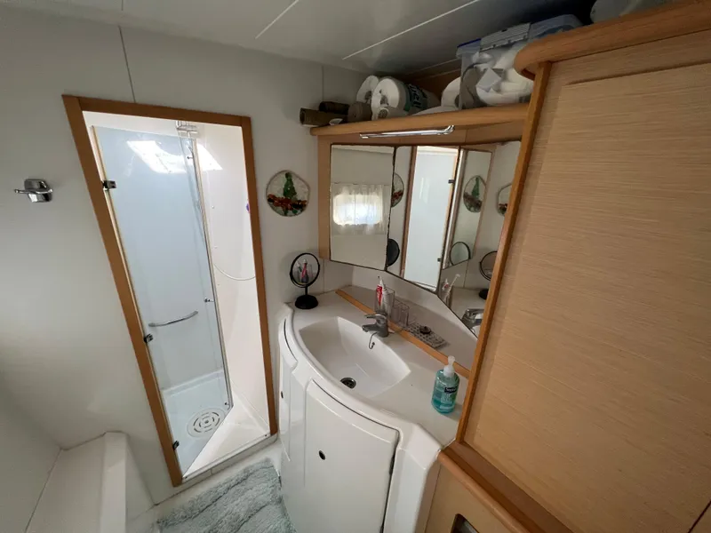 Slide: The Image of Bathroom interior of a 2008 Lagoon 420 catamaran with shower, sink, and storage. - 34