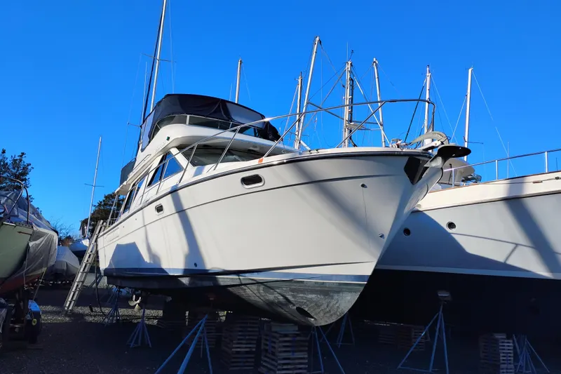 Slide: The Image of 2000 Bayliner 3988 Command Bridge Motoryacht on stands under clear blue sky. - 2