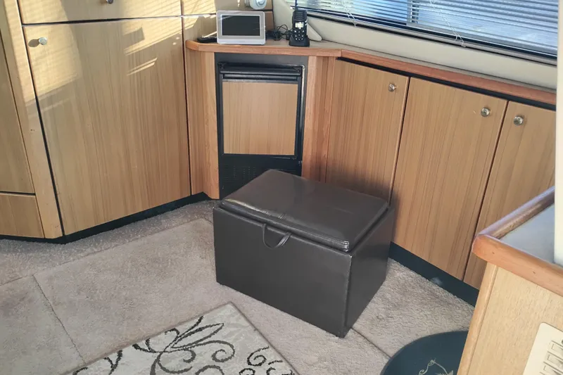 Slide: The Image of Interior of 2000 Bayliner 3988 Command Bridge Motoryacht with wooden cabinets and leather ottoman. - 21