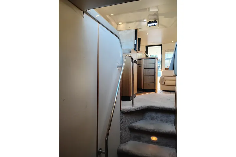 Slide: The Image of Interior view of 2000 Bayliner 3988 Command Bridge Motoryacht, featuring carpeted stairs and modern furnishings. - 43