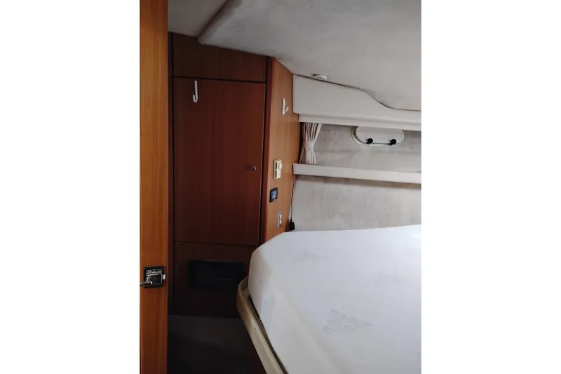 Slide: The Image of Interior cabin of 2000 Bayliner 3988 Command Bridge Motoryacht, featuring wood paneling and bed. - 51