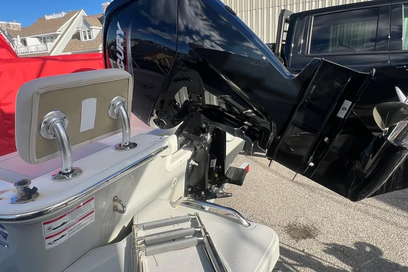 Slide: The Image of 2023 Boston Whaler 170 Montauk boat with Mercury outboard motor, docked outdoors. - 6