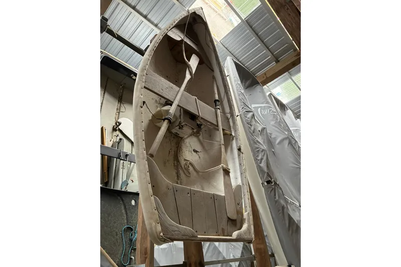Slide: The Image of Vintage 1990 FAIRFIELD row boat stored indoors, showcasing wooden oars and rustic design. - 7