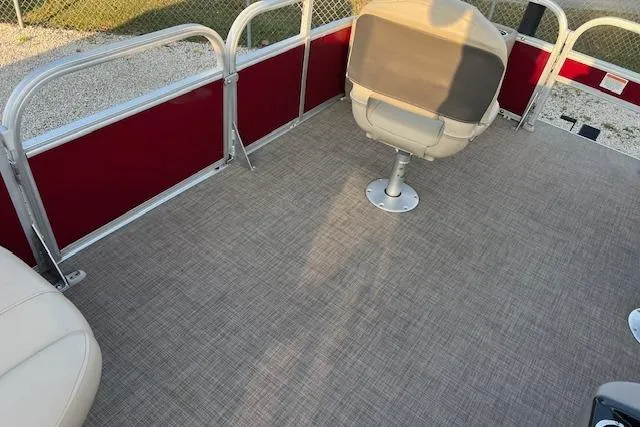 Slide: The Image of 2023 Sun Tracker Bass Buggy 18 DLX interior with beige seating and red paneling. - 11