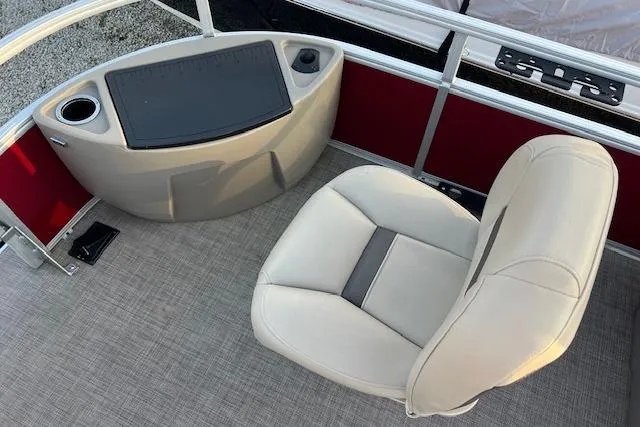 Slide: The Image of 2023 Sun Tracker Bass Buggy 18 DLX boat interior with beige seating and control panel. - 12