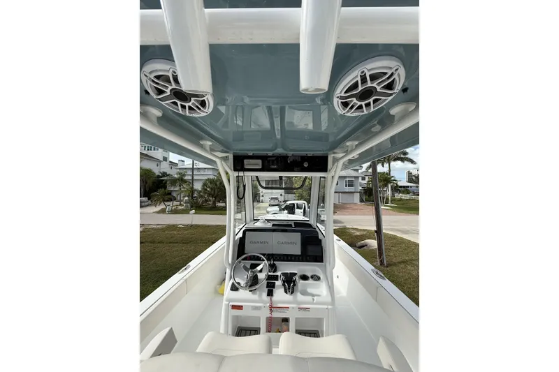 Slide: The Image of 2025 Sea Hunt Escape 28 boat interior with seating and dual engines, docked by a marina. - 7
